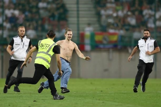 Security personnel deal with a pitch invader during the Pre-season friendly match between Real Madrid and AC Milan at Worthersee Stadion on August...