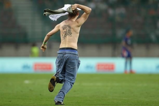 Tattooed pitch invader enters the field of play during the Pre-season friendly match between Real Madrid and AC Milan at Worthersee Stadion on August...