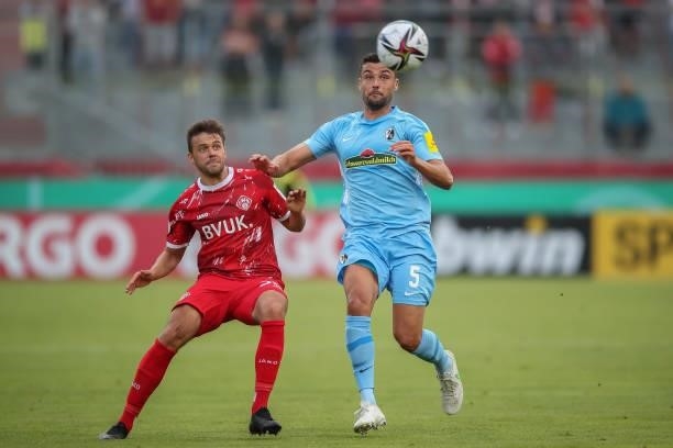 Manuel Gulde of SC Freiburg challenges Robert Herrmann of Wuerzburger Kickers during the DFB Cup first round match between Würzburger Kickers and SC...