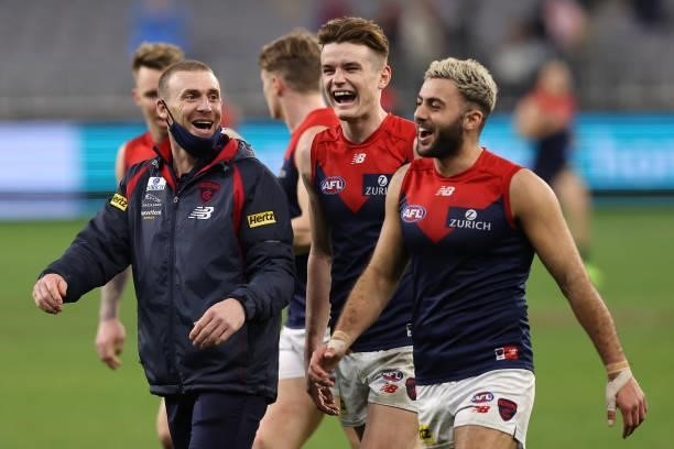 Simon Goodwin, Senior Coach of the Demons shares a moment with Bayley Fritsch and Christian Salem after winning the round 21 AFL match between West...