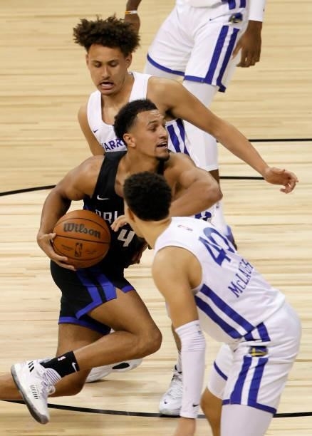 Jalen Suggs of the Orlando Magic drives against Colbey Ross and Jaquori McLaughlin of the Golden State Warriors during the 2021 NBA Summer League at...