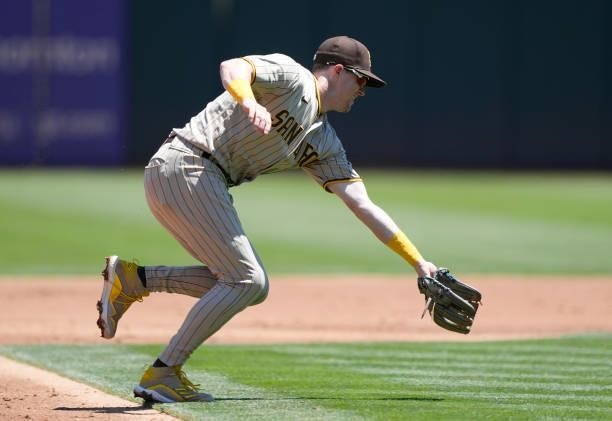 Jake Cronenworth of the San Diego Padres goes down to field a ground ball off the bat of Sean Murphy of the Oakland Athletics in the bottom of the...