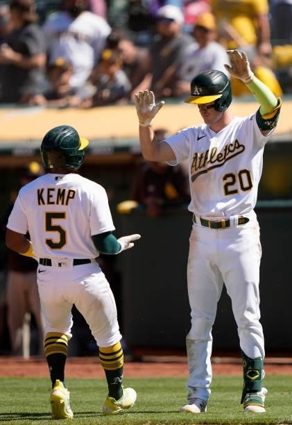 Josh Harrison and Mark Canha of the Oakland Athletics celebrates after Kemp scored against the San Diego Padres in the bottom of the ninth at...