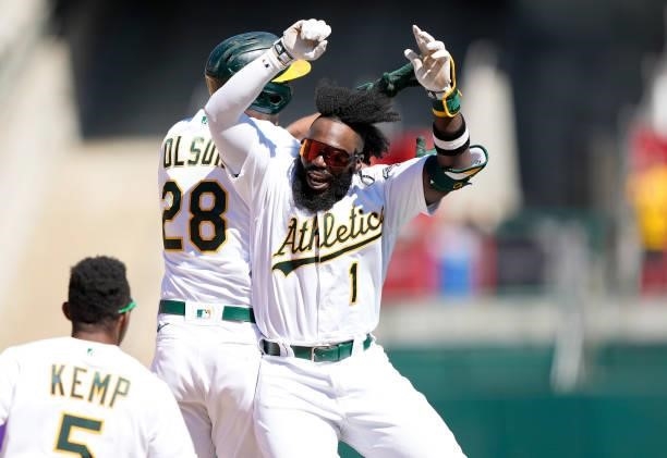 Matt Olson and Josh Harrison of the Oakland Athletics celebrates after Olson hit a walk-off two-run RBI double in the bottom of the tenth inning to...