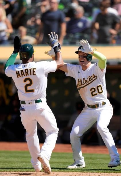 Mark Canha and Starling Marte of the Oakland Athletics celebrates after they both scored on a walk-off RBI double hit by Matt Olson to defeat the San...