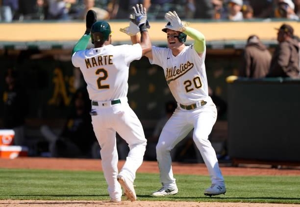 Mark Canha and Starling Marte of the Oakland Athletics celebrates after they both scored on a walk-off RBI double hit by Matt Olson to defeat the San...