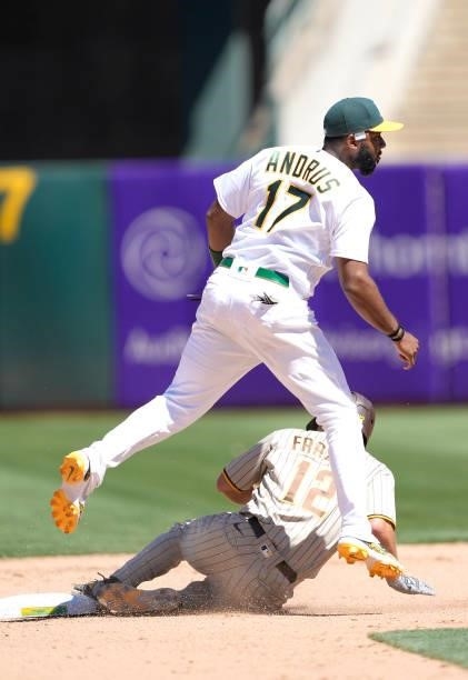 Elvis Andrus of the Oakland Athletics completes the double-play throwing over the top of Adam Frazier of the San Diego Padres in the top of the...