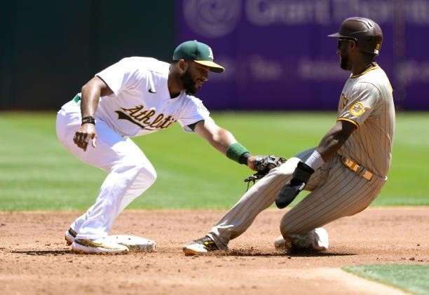 Jurickson Profar of the San Diego Padres attempting to steal second base gets tagged out by Elvis Andrus of the Oakland Athletics in the top of the...