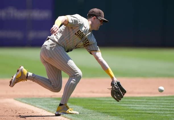 Jake Cronenworth of the San Diego Padres goes down to field a ground ball off the bat of Sean Murphy of the Oakland Athletics in the bottom of the...