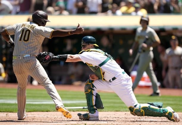 Jurickson Profar of the San Diego Padres gets tagged out at home plate by Sean Murphy of the Oakland Athletics in the top of the fourth inning at...
