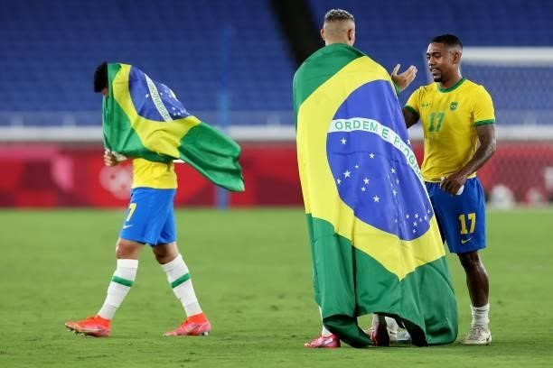 Richarlison of Team Brazil celebrates their side's victory with a flag of Brazil with team mate Malcom after the Men's Gold Medal Match between...