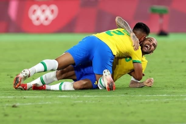 Gabriel Menino and Dani Alves of Team Brazil celebrate their side's victory after the Men's Gold Medal Match between Brazil and Spain on day fifteen...