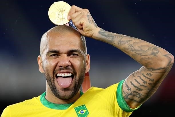 Gold medalist Dani Alves of Team Brazil celebrates with their gold medal during the Men's Football Competition Medal Ceremony on day fifteen of the...