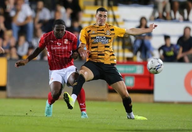 Tyreece Simpson of Swindon Town plays the ball under pressure from Lloyd Jones of Cambridge United during the Carabao Cup 1st Round match between...