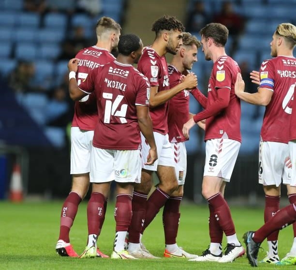 Kion Etete of Northampton Town is congratulated by team mates after scoring his sides first goal during the Carabao Cup 1st round match between...