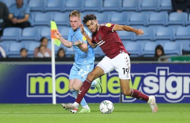 Kion Etete of Northampton Town moves with the ball past Josh Reid of Coventry City during the Carabao Cup 1st round match between Coventry City and...
