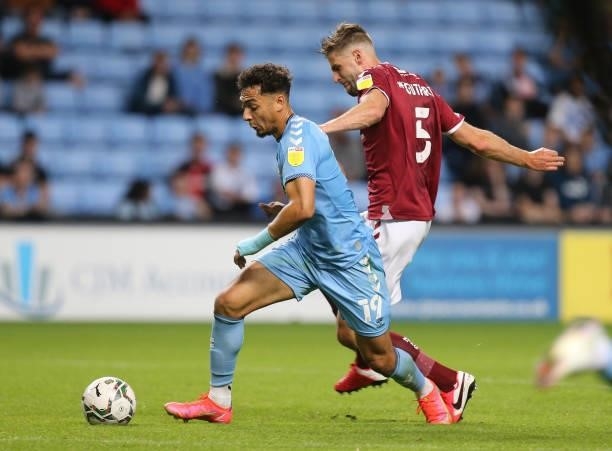 Tyler Walker of Coventry City attempts to move away with the ball under pressure from Jon Guthrie of Northampton Town during the Carabao Cup 1st...