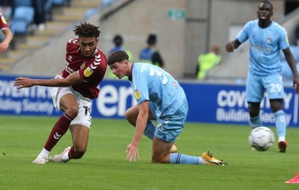 Kion Etete of Northampton Town plays the ball watched by Ryan Howley of Coventry City during the Carabao Cup 1st round match between Coventry City...