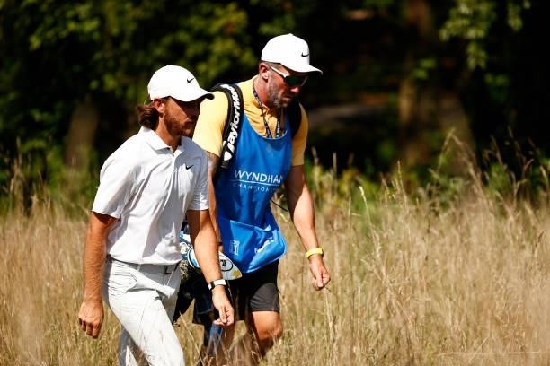 Tommy Fleetwood of England and caddie Ian Finnis walk off the 13th tee during the first round of the Wyndham Championship at Sedgefield Country Club...