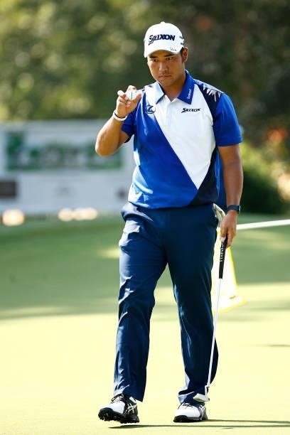 Hideki Matsuyama of Japan waves on the 14th green during the first round of the Wyndham Championship at Sedgefield Country Club on August 12, 2021 in...
