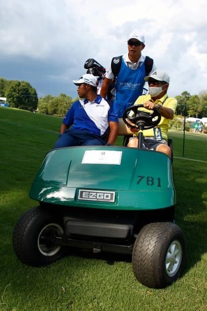 Hideki Matsuyama of Japan and caddie Shota Hayafuji are driven off the course near the 15th fairway during a delay due to inclement weather during...