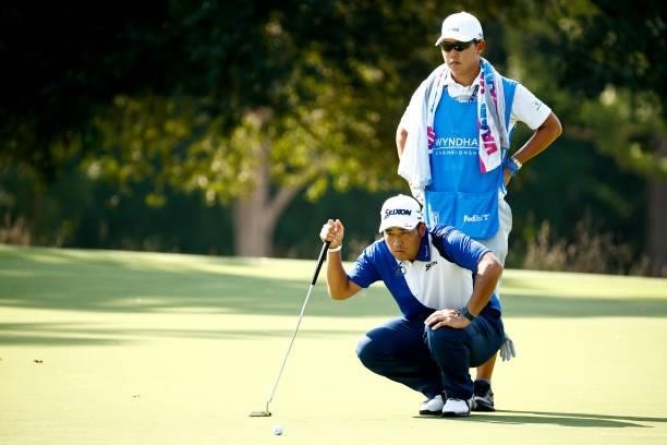 Hideki Matsuyama of Japan and caddie Shota Hayafuji lines up a putt on the 14th green during the first round of the Wyndham Championship at...