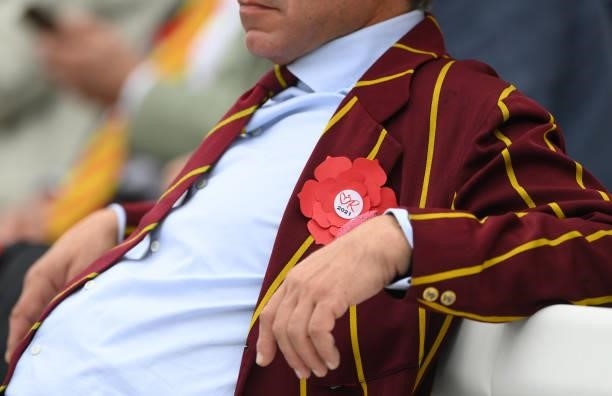An MCC member wearing a red rosette on Ruth Strauss Foundation Day during day two of the Second Test Match between England and India at Lord's...