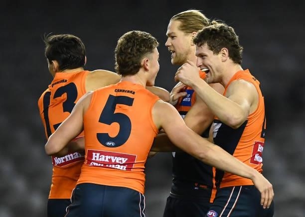 Jacob Hopper of the Giants is congratulated by team mates after kicking a goal during the round 22 AFL match between Greater Western Sydney Giants...