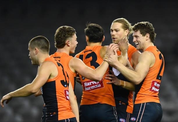 Jacob Hopper of the Giants is congratulated by team mates after kicking a goal during the round 22 AFL match between Greater Western Sydney Giants...