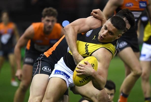 Dion Prestia of the Tigers is tackled during the round 22 AFL match between Greater Western Sydney Giants and Richmond Tigers at Marvel Stadium on...