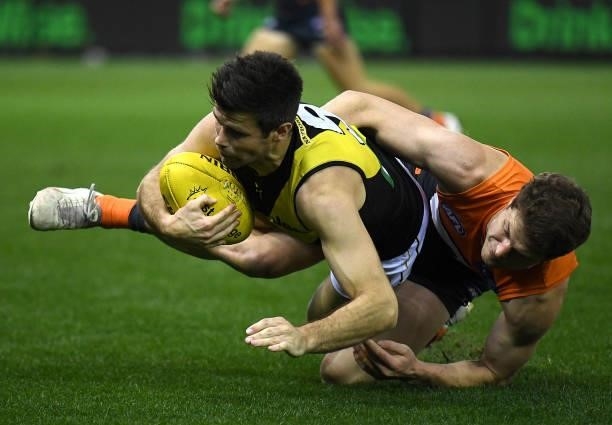 Trent Cotchin of the Tigers is tackled by Jacob Hopper of the Giants during the round 22 AFL match between Greater Western Sydney Giants and Richmond...