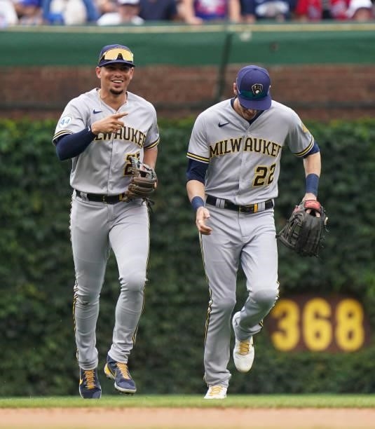 Willy Adames and Christian Yelich of the Milwaukee Brewers reacts after the fourth inning against the Chicago Cubs at Wrigley Field on August 12,...