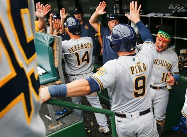 Manny Pina of the Milwaukee Brewers celebrates in the dugout after a two-run home run during the sixth inning of a game against the Chicago Cubs at...