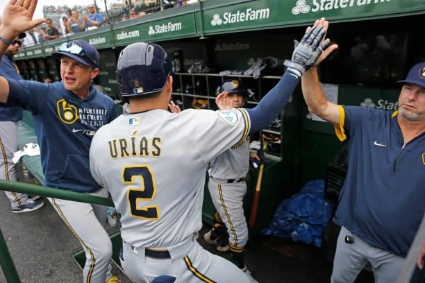 Luis Urias of the Milwaukee Brewers celebrates in the dugout following his two-run home run during the seventh inning of a game against the Chicago...
