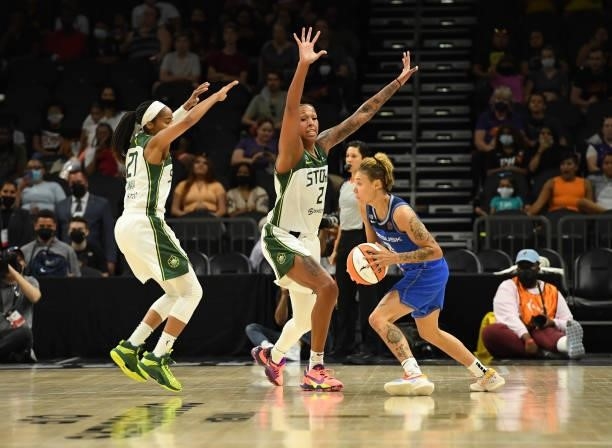 Natisha Hiedeman of the Connecticut Sun looks to pass the ball while being defended by Mercedes Russel and Jordin Canada of the Seattle Storm during...