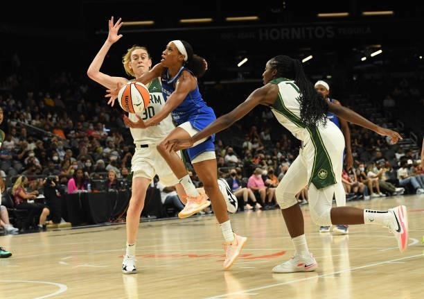 Jasmine Thomas of the Connecticut Sun drives to the basket while being defended by Breanna Stewart and Ezi Magbegor of the Seattle Storm during the...