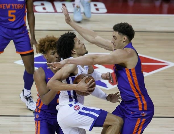 Cade Cunningham of the Detroit Pistons drives to the basket against between Miles McBride and Reid Travis of the New York Knicks during the 2021 NBA...
