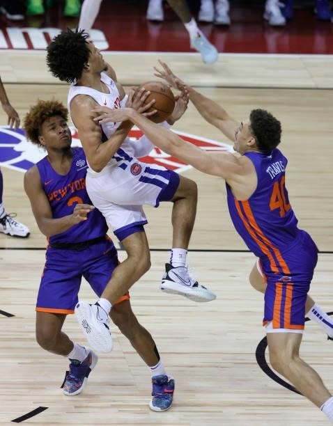 Cade Cunningham of the Detroit Pistons drives to the basket against between Miles McBride and Reid Travis of the New York Knicks during the 2021 NBA...