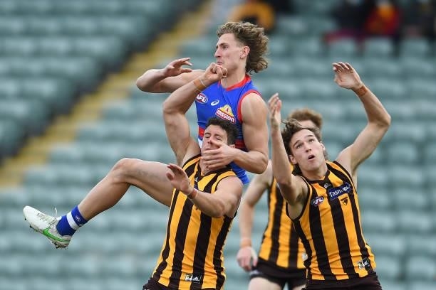 Aaron Naughton of the Bulldogs and Kyle Hartigan and Jack Scrimshaw of the Hawks compete for the ball during the round 22 AFL match between Hawthorn...