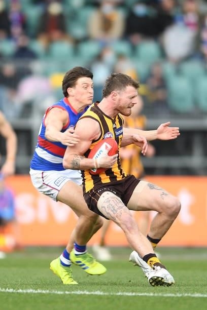 Blake Hardwick of the Hawks is tackled by Mitch Hannan of the Bulldogs during the round 22 AFL match between Hawthorn Hawks and Western Bulldogs at...