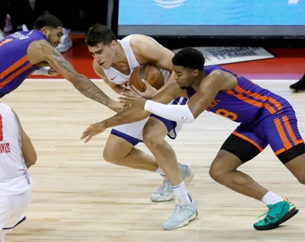 Obi Toppin and M.J. Walker of the New York Knicks try to steal the ball from Luka Garza of the Detroit Pistons during the 2021 NBA Summer League at...