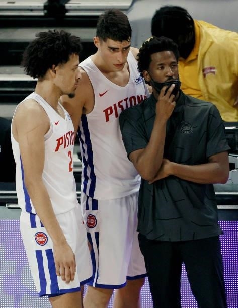 Cade Cunningham and Luka Garza talk with head coach J.D. DuBois of the Detroit Pistons before checking in to a game against the New York Knicks...