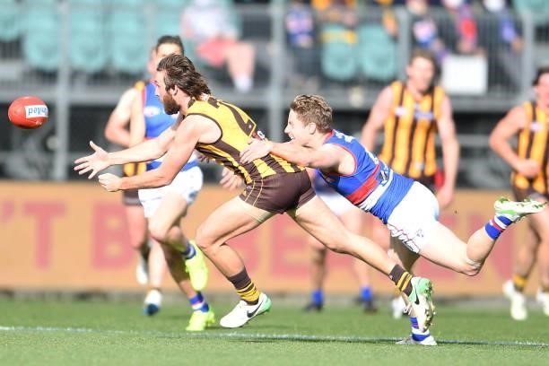 Tom Phillips of the Hawks is tackled by Lachie Hunter of the Bulldogs during the round 22 AFL match between Hawthorn Hawks and Western Bulldogs at...