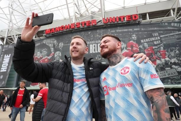 Manchester United fans pose for a selfie outside the stadium prior to the Premier League match between Manchester United and Leeds United at Old...