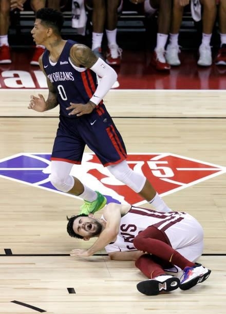 Didi Louzada of the New Orleans Pelicans looks down the court as Chandler Vaudrin of the Cleveland Cavaliers reacts after suffering an injury in...