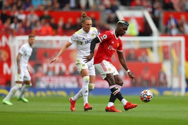 Paul Pogba of Manchester United is challenged by Luke Ayling of Leeds United during the Premier League match between Manchester United and Leeds...
