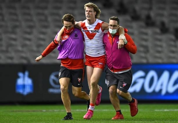 Nick Blakey of the Swans is helped from the ground by trainers during the round 22 AFL match between North Melbourne Kangaroos and Sydney Swans at...