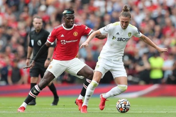 Luke Ayling of Leeds United is challenged by Paul Pogba of Manchester United during the Premier League match between Manchester United and Leeds...