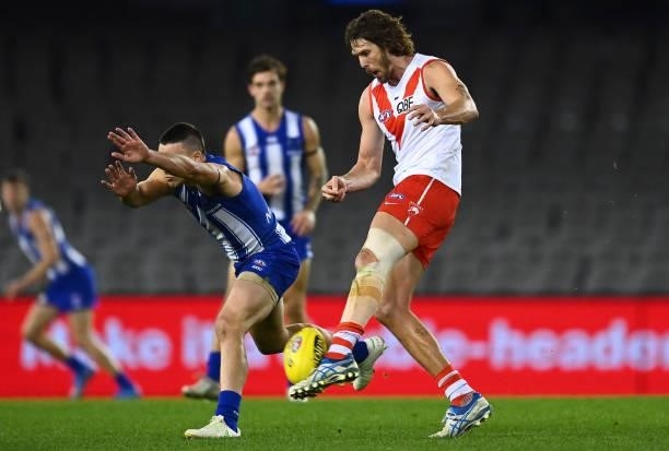 Tom Hickey of the Swans kicks whilst Luke Davies-Uniacke of the Kangaroos attempts to smother during the round 22 AFL match between North Melbourne...
