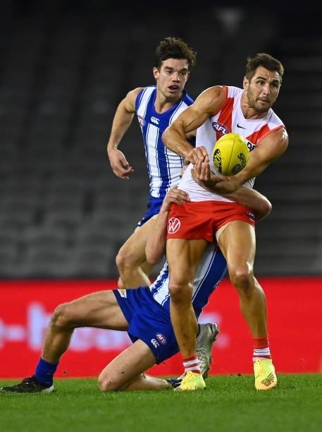 Josh P. Kennedy of the Swans handballs whilst being tackled by Jed Anderson of the Kangaroos during the round 22 AFL match between North Melbourne...